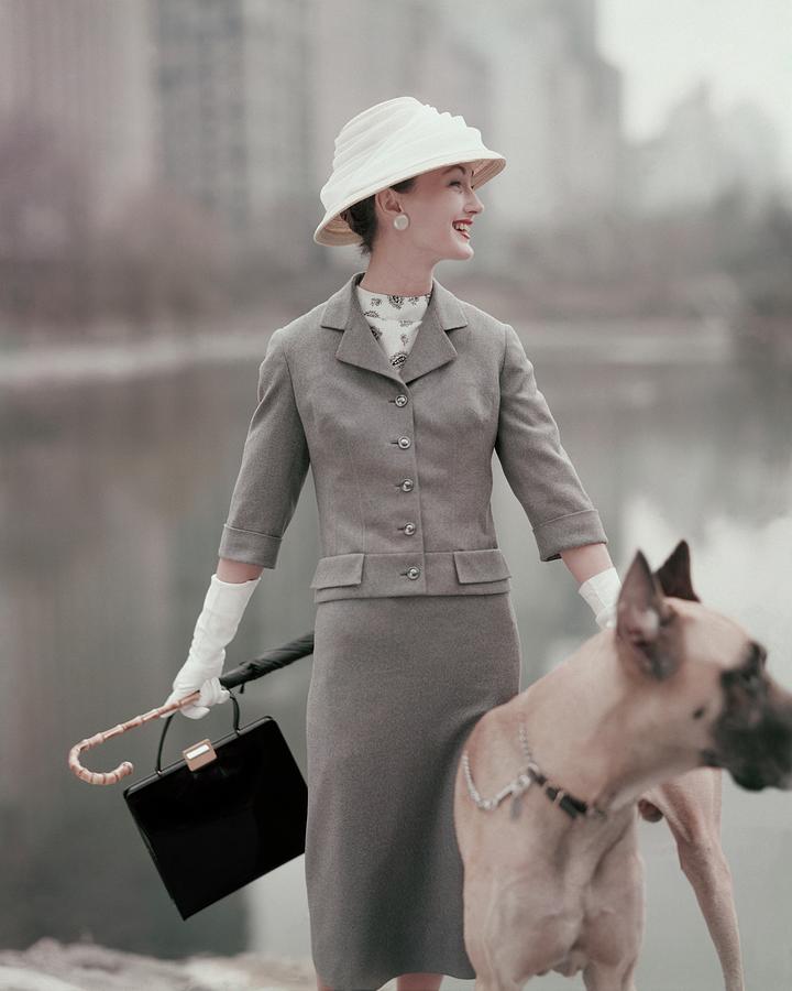 A Model Wearing A Gray Suit With A Dog Photograph by Karen Radkai