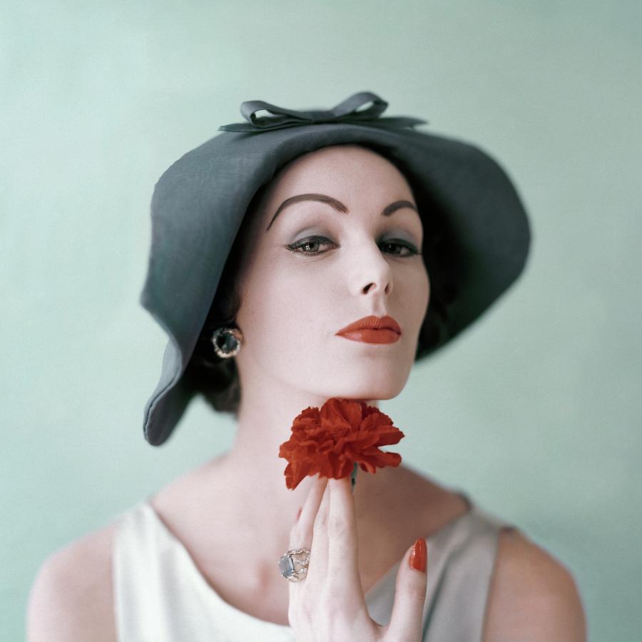 A Model Wearing A Hat And Holding A Flower Photograph by Karen Radkai