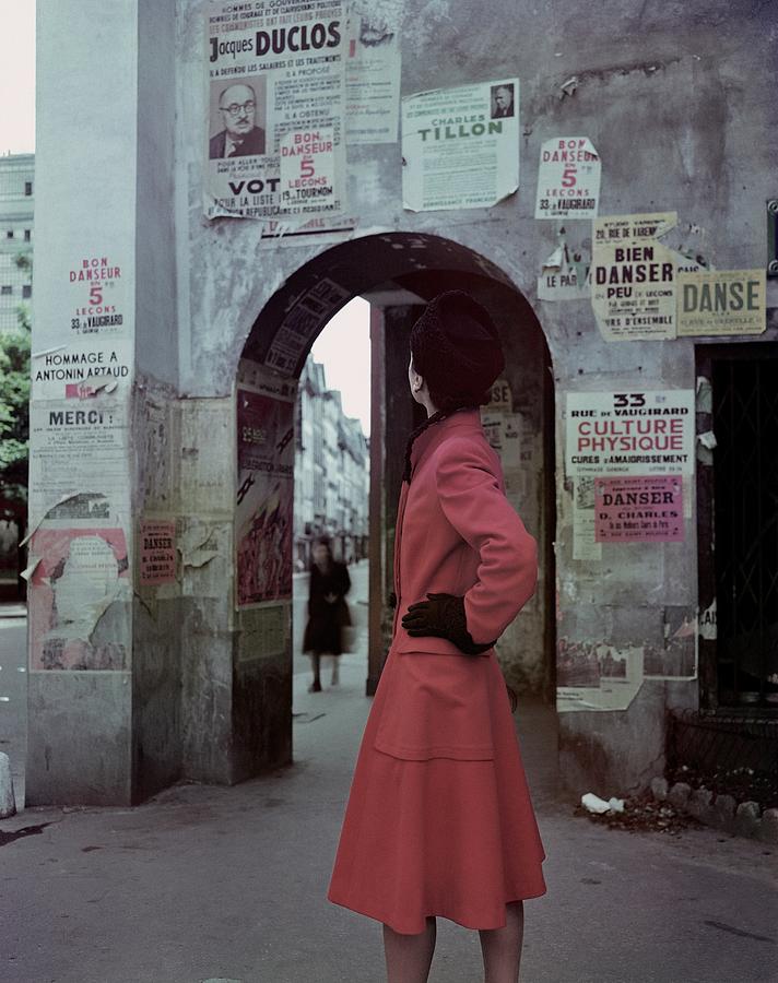 A Model Wearing A Red Coat On A Street In Paris Photograph by John Rawlings