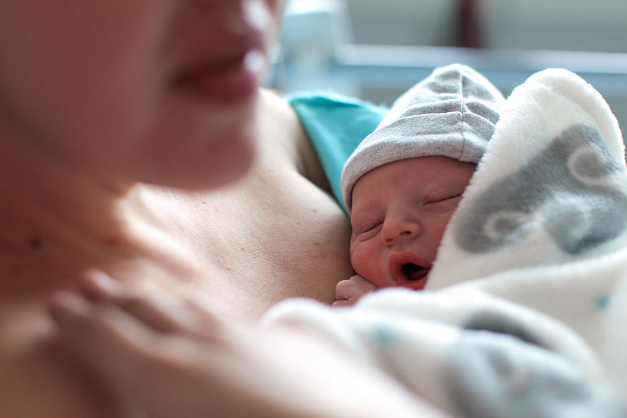 a Newborn baby boy breastfeeding for the first time. Photograph by Petri Oeschger