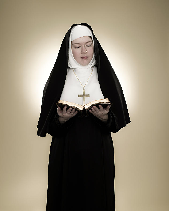 A nun reading a bible Photograph by Image Source