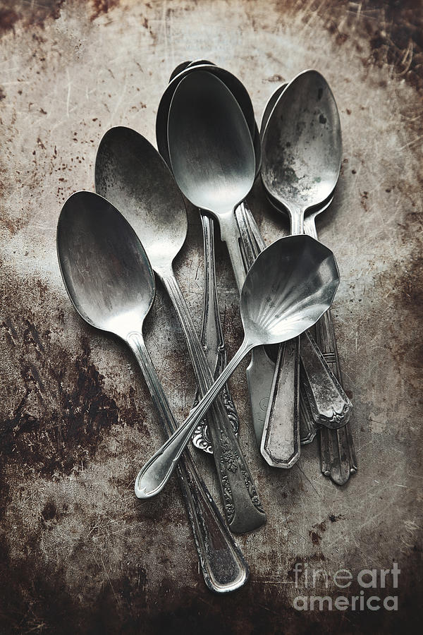 A pile of old silver spoons on grungy background Photograph by Sandra Cunningham