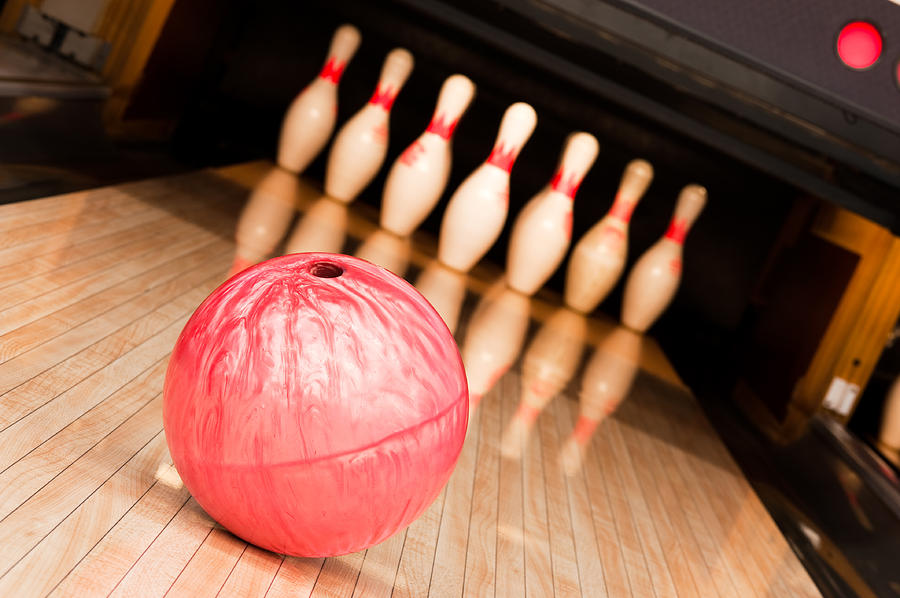 A pink bowling ball going toward pins Photograph by Avdeev007