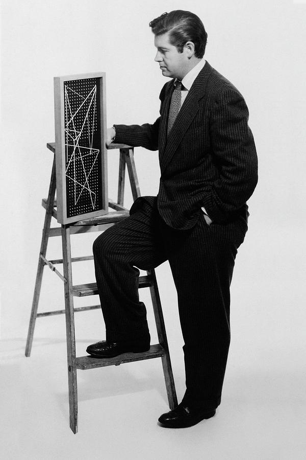 A Portrait Of Paul Mccobb Leaning On A Ladder Photograph by Herbert Matter