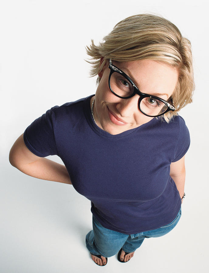 A Pretty Teenage Caucasian Girl With Short Blond Hair And Retro Glasses Is Wearing A Purple Teeshirt And Grinning Up At The Camera Photograph by Photodisc