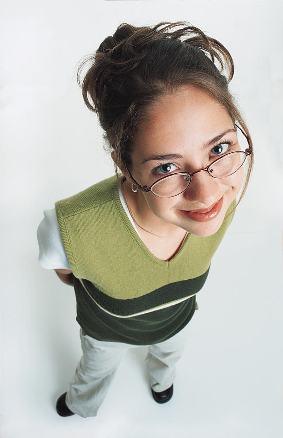A Pretty Teenage Girl Wearing Glasses And A Green Vest Smiles Shyly Up At The Camera Photograph by Photodisc