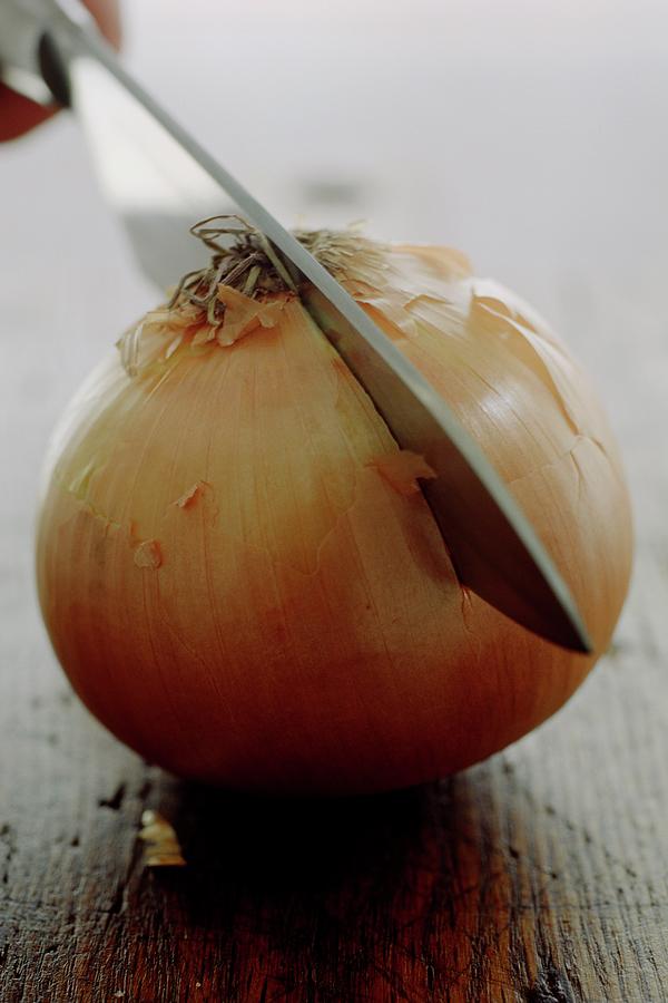 A Raw Onion Being Cut In Half Photograph by Romulo Yanes
