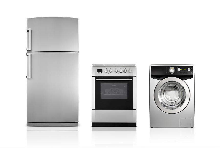 A silver fridge, an oven and dryer lined up side by side Photograph by S-cphoto