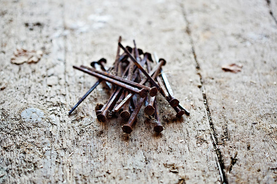 A Small Pile Of Rusty Nails On A Wooden Photograph by Richard Boll