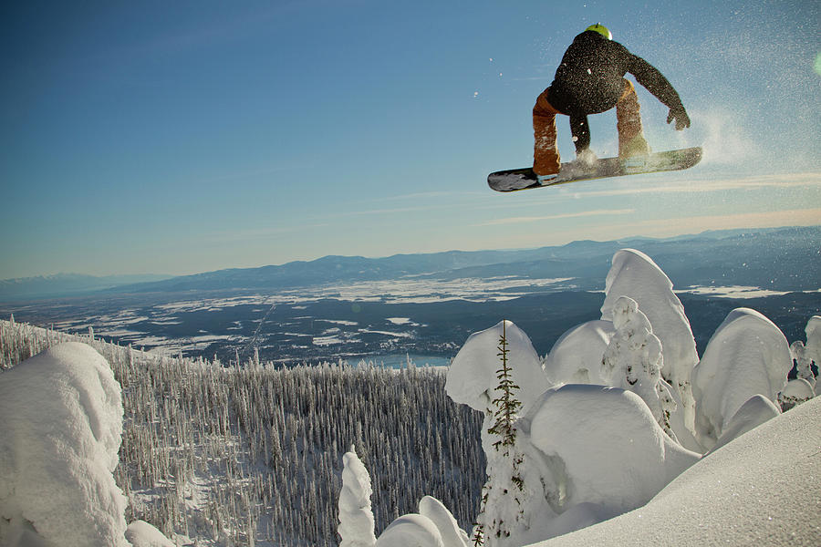 A Snowboarder Airs Over Some Snowcoated Photograph by Noah Couser