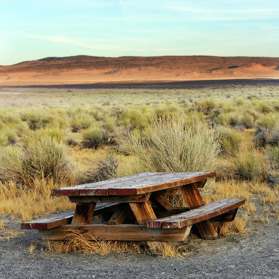 Desert Photograph - A Solitary Wooden Picnic Bench by Ron Koeberer
