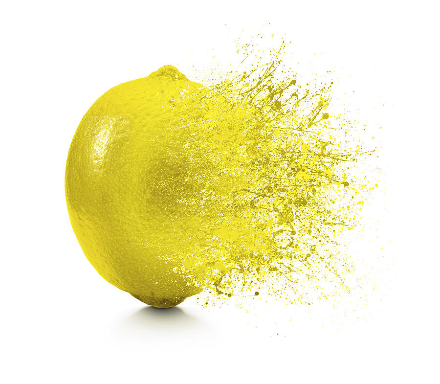 A splash coming off of a lemon on a white background Photograph by Rbozuk