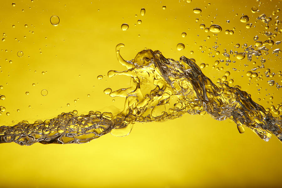 A splash of water over a yellow background Photograph by Hirkophoto