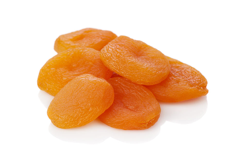 A stack of dried apricots against a white background Photograph by FerhatMatt