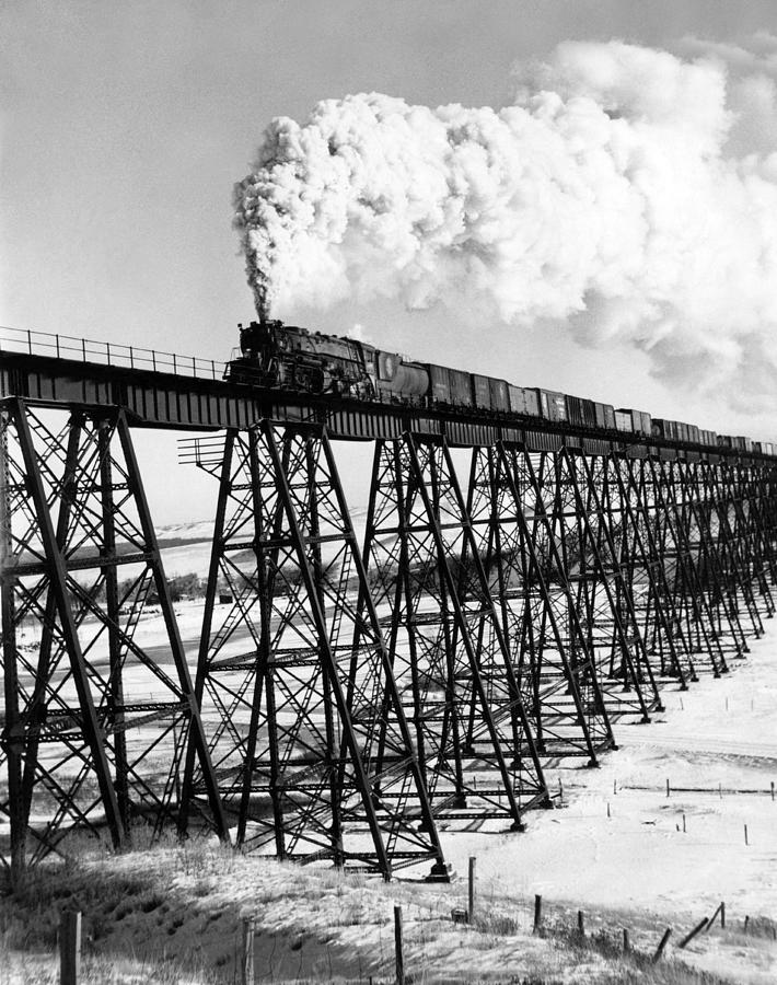 Architecture Photograph - A Steam Engine On Trestle by Underwood Archives