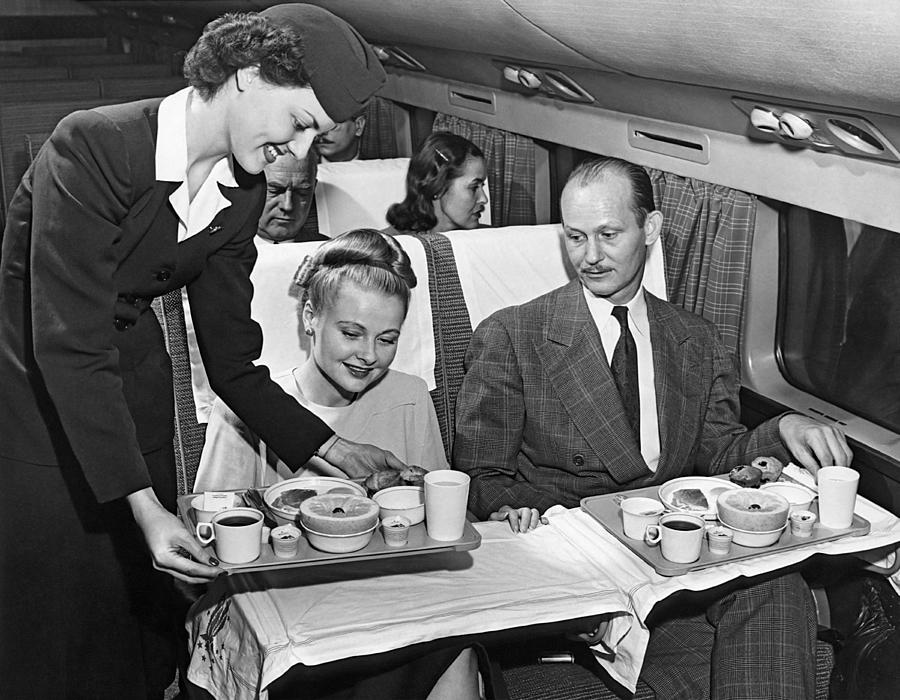 Airplane Photograph - A Stewardess Serving Breakfast by Underwood Archives