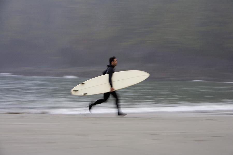 A Surfer, Running With Board Along The Photograph