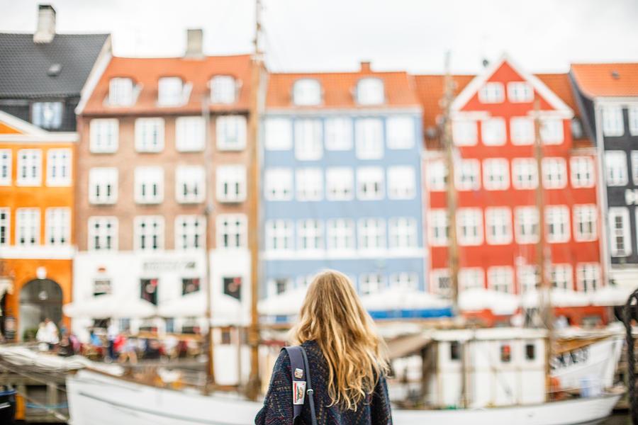 A tourist looks at a view of Nyhavn, Copenhagen, Denmark Photograph by Annapurna Mellor