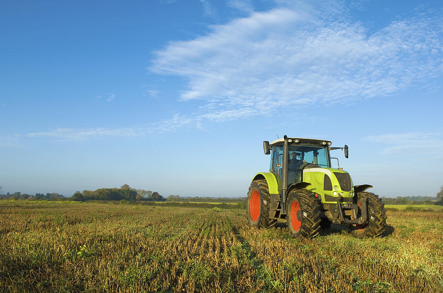 A tractor in a stubble field in Gloucestershire. Photograph by Mint Images