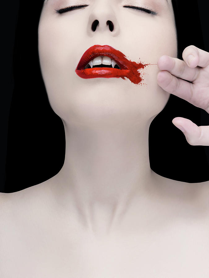 A Vampire Wiping Blood From Her Mouth Photograph by Colin Anderson