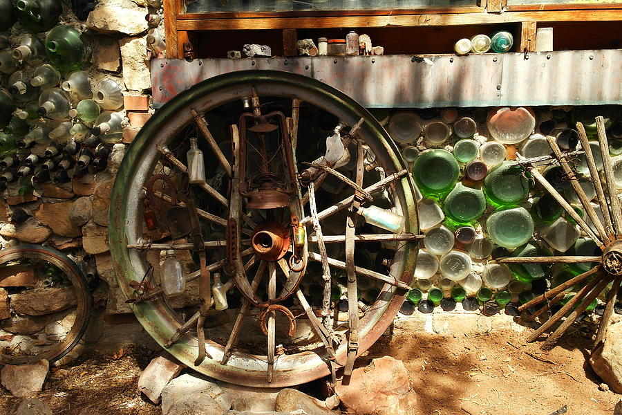 Bottle Photograph - A Wagon Wheel And Wall Of Bottles by Jeff Swan
