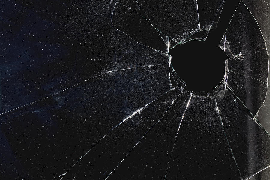 A window with a hole broken through the glass, night Photograph by Patrick Strattner