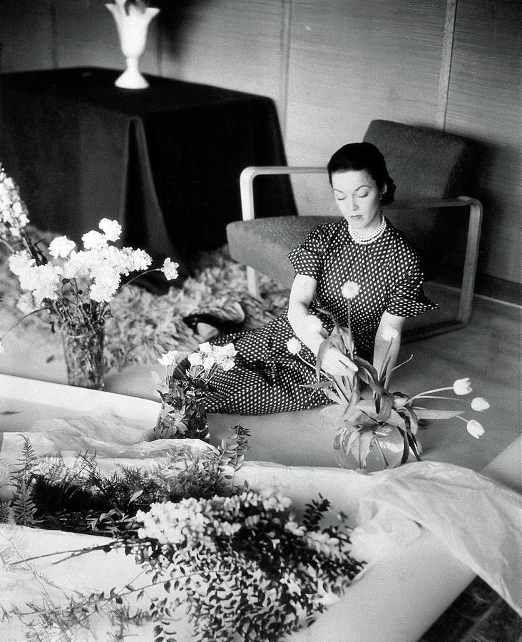 A Woman Arranging Flowers Photograph by Horst P. Horst