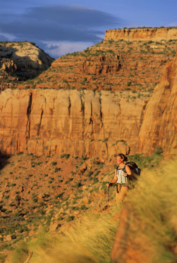 Backpack Photograph - A Woman Hikes Along The Base Of A Wall by Rich Wheater Backpack Photograph - A Woman Hikes Along The Base Of A Wall by Rich Wheater