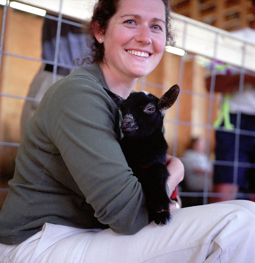 Goat Photograph - A Woman Holds A Baby Goat by Karl Schatz