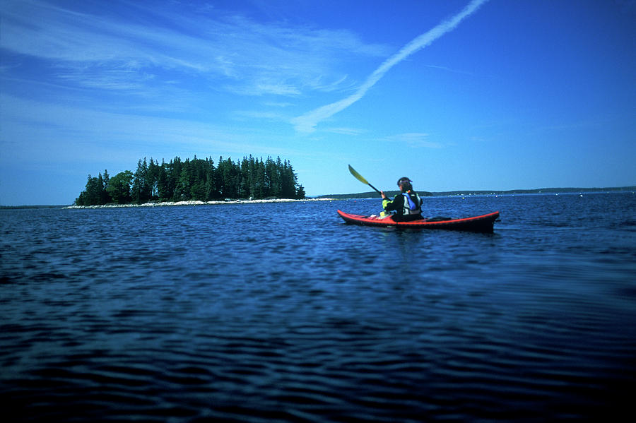 Sports Photograph - A Woman Paddles Her Sea Kayak by David McLain