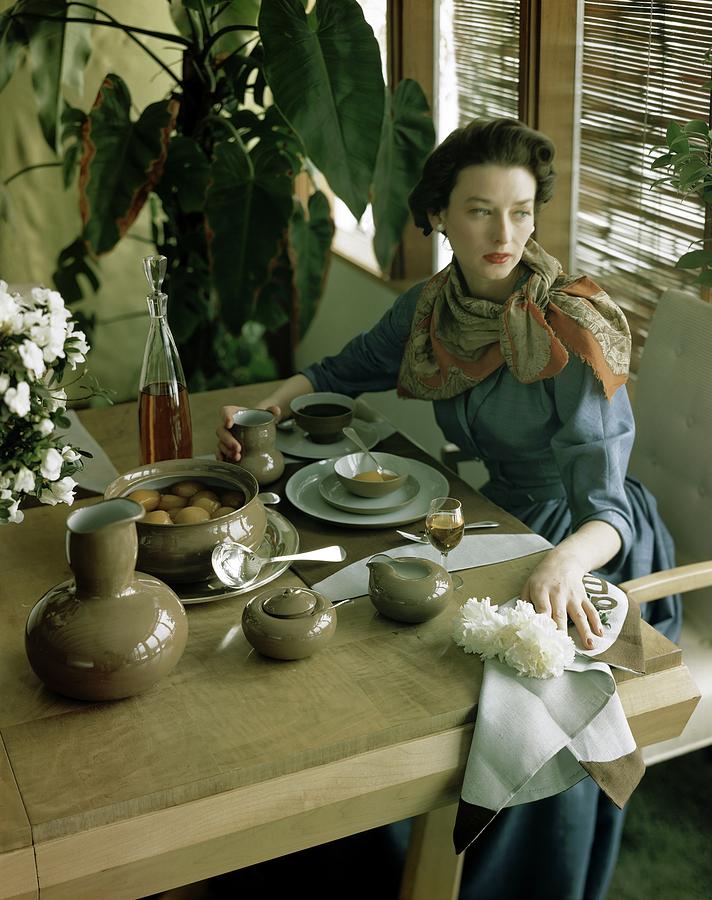 A Woman Sitting At A Dining Table Photograph by Horst P. Horst