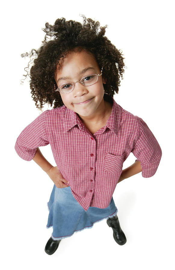 A Young African American Girl In A Jeans Skirt And A Red Shirt Puts Her Hands On Her Hips And Smiles Up At The Camera Photograph by Photodisc