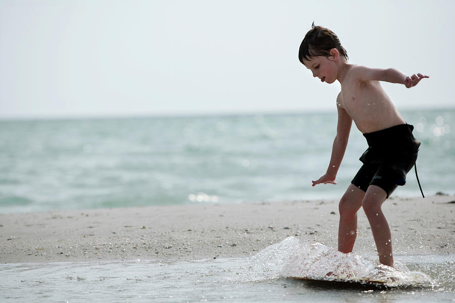 A Young Boy In A Wetsuit Surfs Photograph by Chris Ross - Pixels