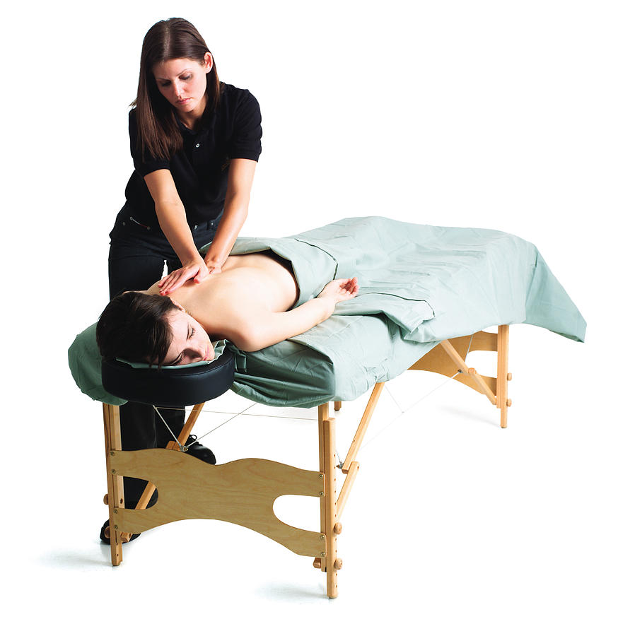 A Young Caucasian Female Masseuse Massages A Woman Lying On The Table Photograph by Photodisc