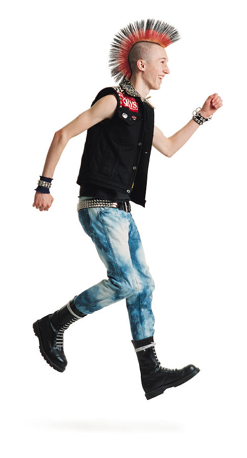 A Young Caucasian Male Punker With A Colorful Mohawk In Jeans And Black Vest Jumps Up And Smiles Photograph by Photodisc