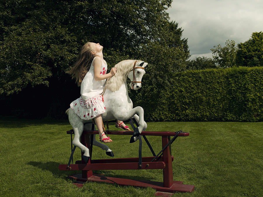 A young girl on a rocking horse Photograph by Nick Daly
