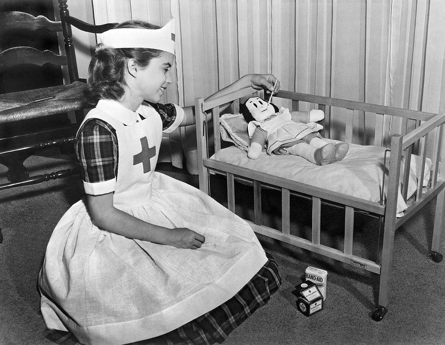 A young girl plays nurse to her Little Lulu doll. Photograph by Underwood Archives