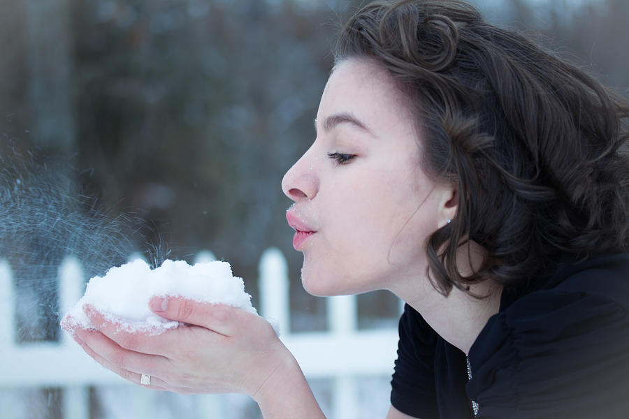 Winter Photograph - A Young Lady Blows Snow by Veda Gonzalez