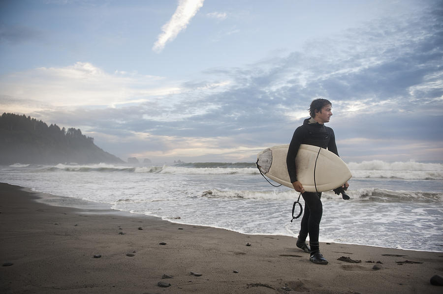 Beach Photograph - A Young Man Carries His Surfboard Down by Helene Cyr