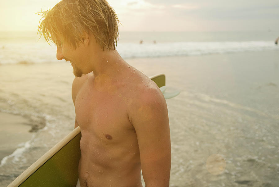 Beach Photograph - A Young Man Holds A Surfboard by Lacey Ann Johnson