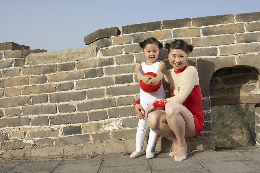 A young woman and a girl standing on the Great Wall of China. Photograph by Blue Jean Images
