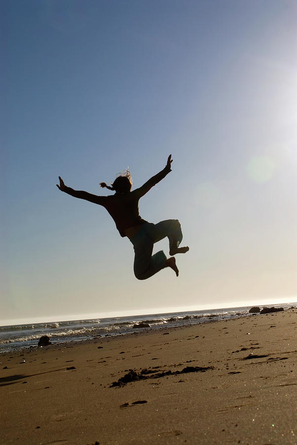 A Young Woman Leaps In The Air While Photograph by Kyle George - Fine ...