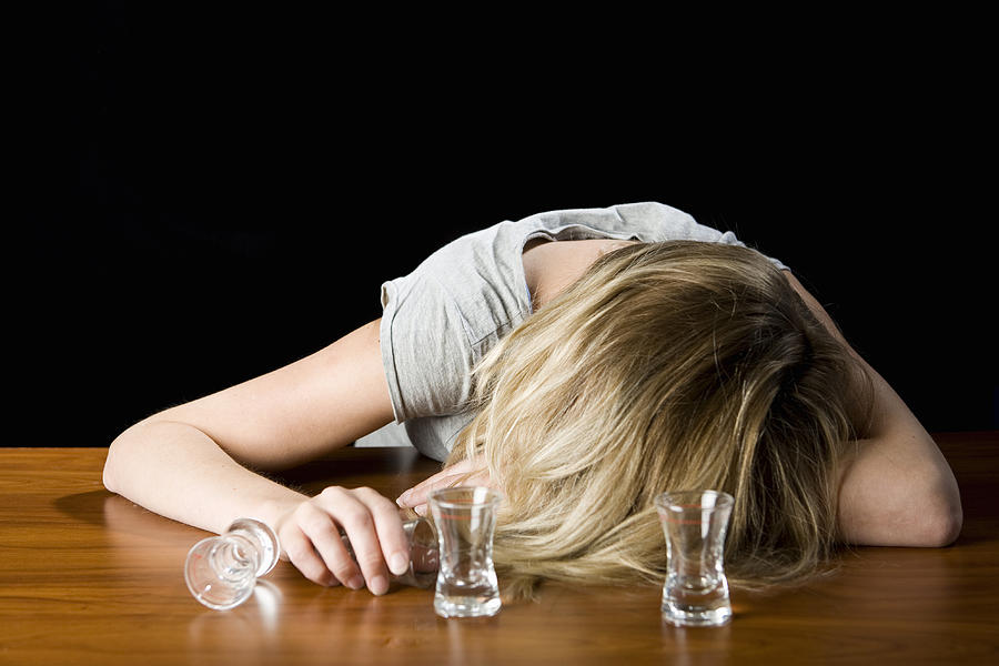 A young woman passed out drunk on a bar counter Photograph by Patrick Strattner