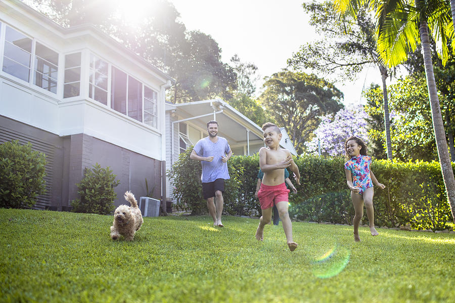 Aboriginal family enjoying the day in the garden at home Photograph by Xavierarnau