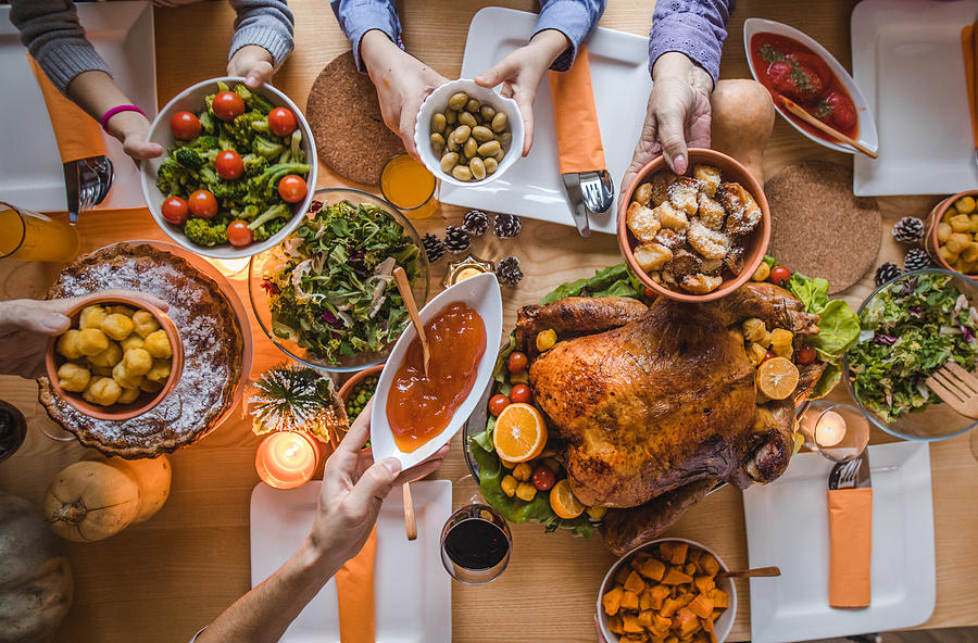 Above view of passing food during Thanksgiving dinner. Photograph by Skynesher