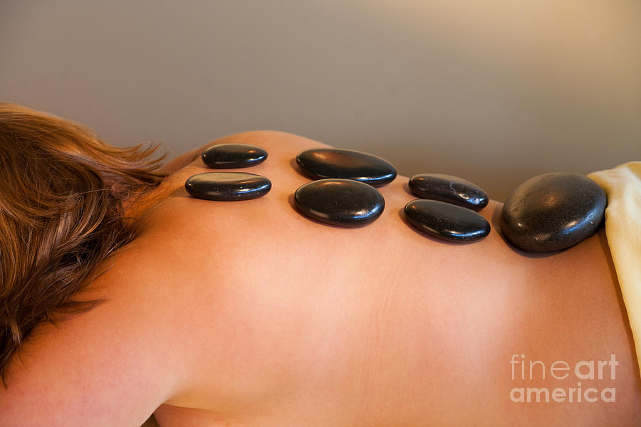 Adult woman receiving a hot rocks spa treatment on her back. Photograph by Don Landwehrle