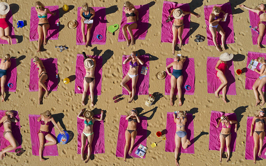 Aerial shot of duplicated woman sunbathing on beach Photograph by Peter Cade