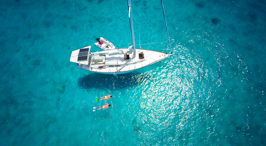 Aerial View Of Couple Snorkeling Next To A Luxury Sailboat Photograph by Cdwheatley