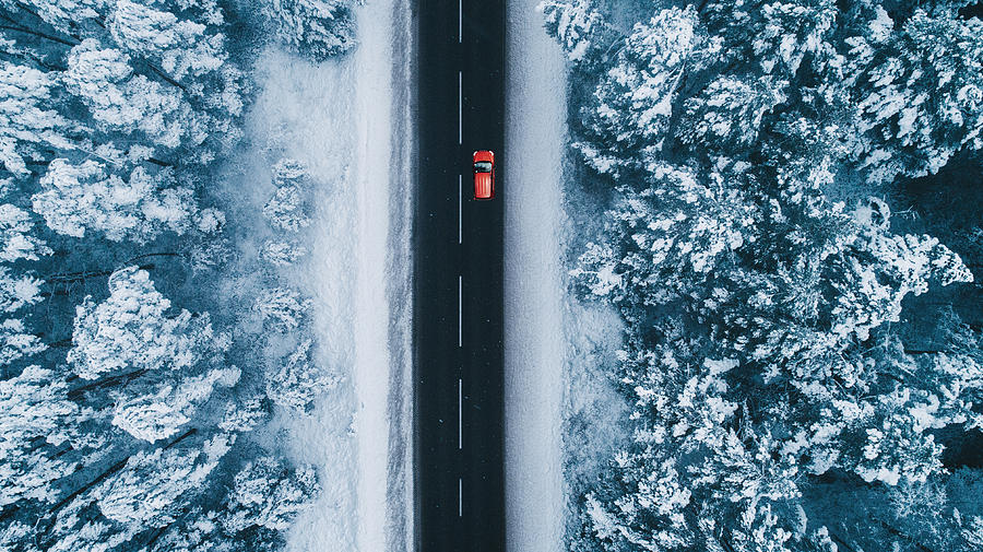 Aerial view of road in winter with red car on it Photograph by Oleh_Slobodeniuk