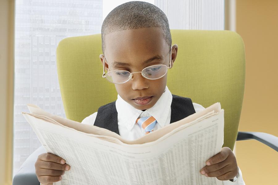 African American boy reading newspaper Photograph by Jose Luis Pelaez Inc